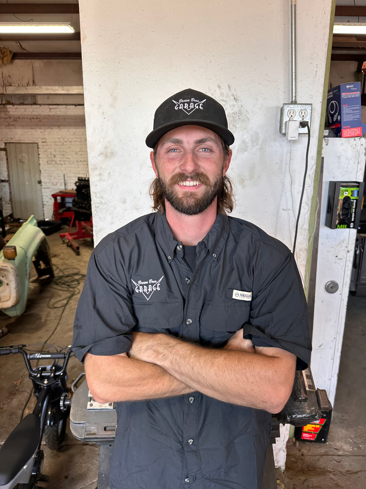 Brown Bros. crew member in the shop wearing the embroidered logo trucker cap and Magellan shirt