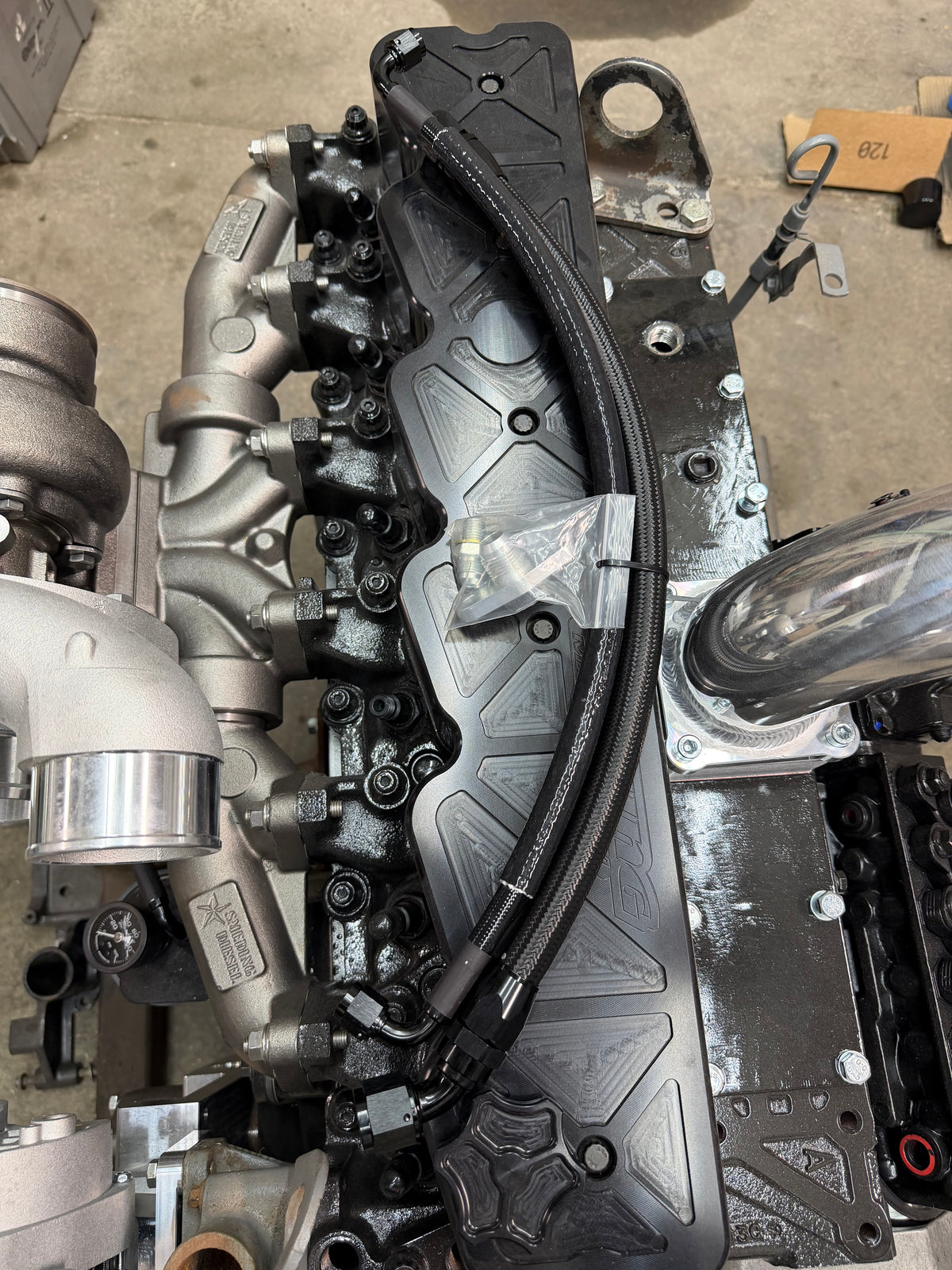 Oil feed line with heat sleeve routed along a Cummins valve cover to a high-mount turbo