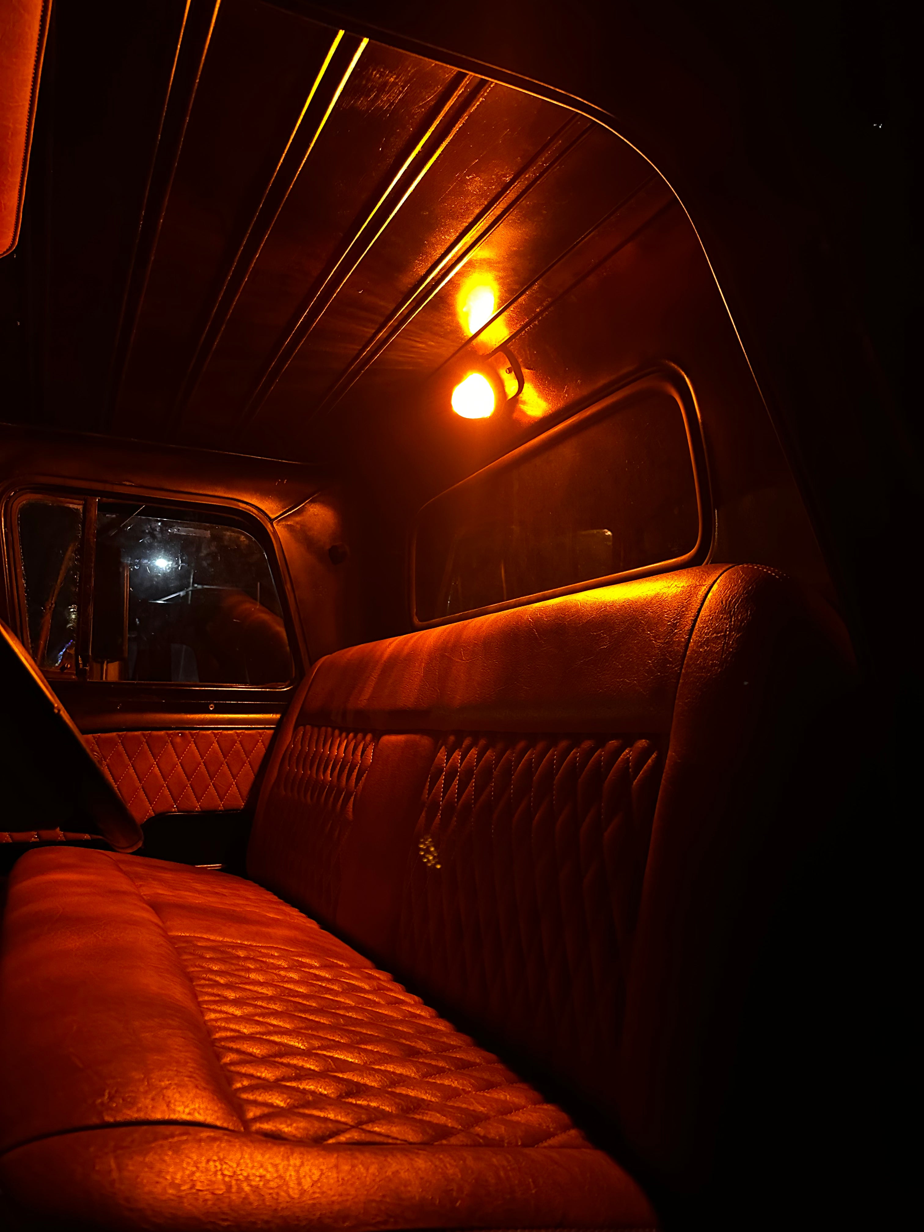 Watermelon dome light lighting a classic Chevy truck cab at night