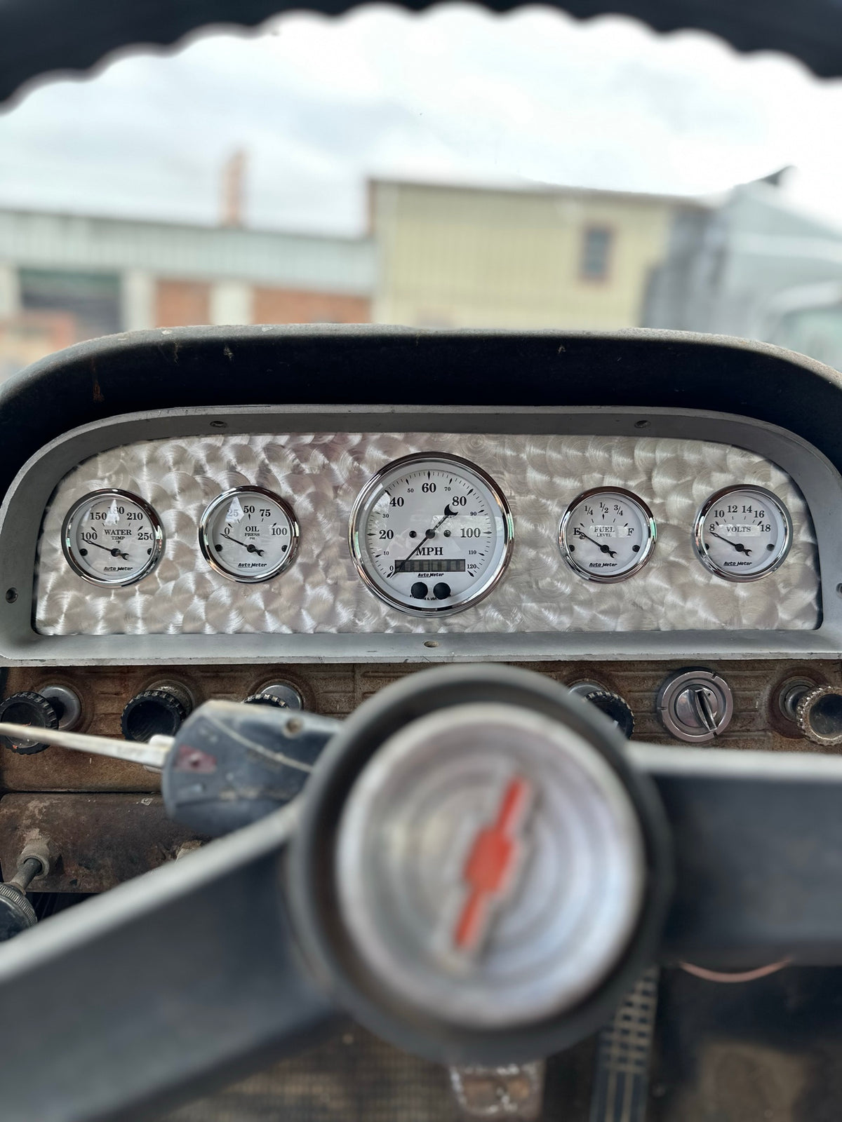 Gauge cluster in a Chevy truck dash, seen past the steering wheel