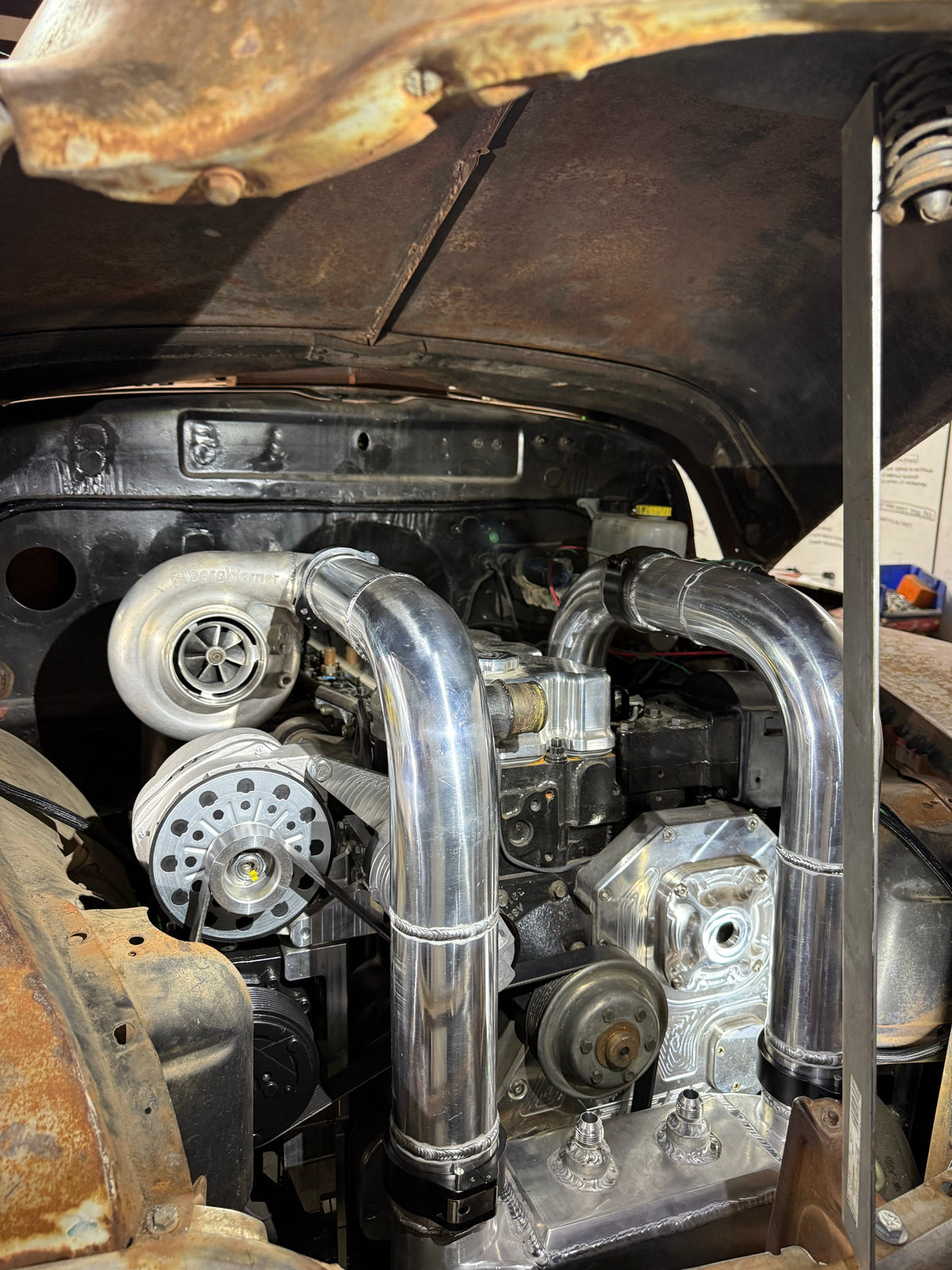 Turbo and polished intercooler piping in Roadrunner's engine bay