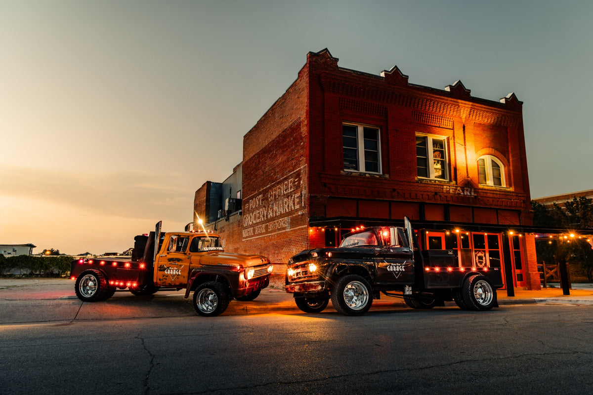 Brown Bros. builds parked at a brick building at dusk